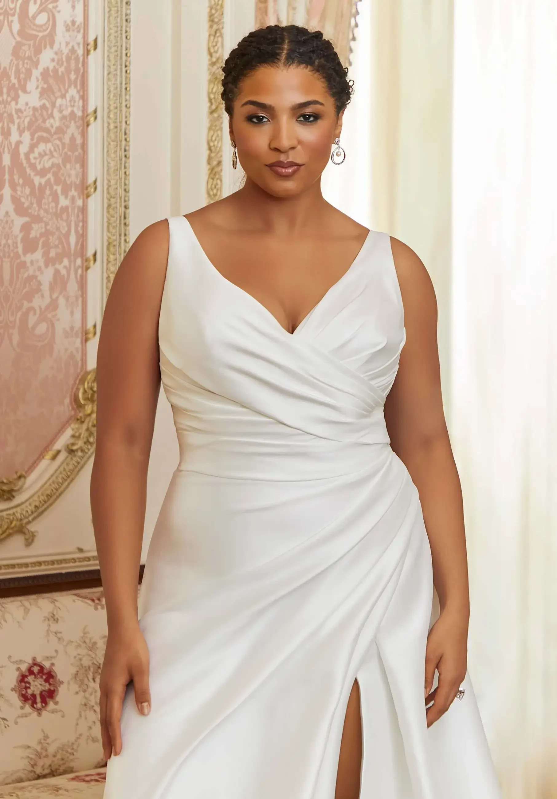 model is wearing a sleeveless plus size bridal gown