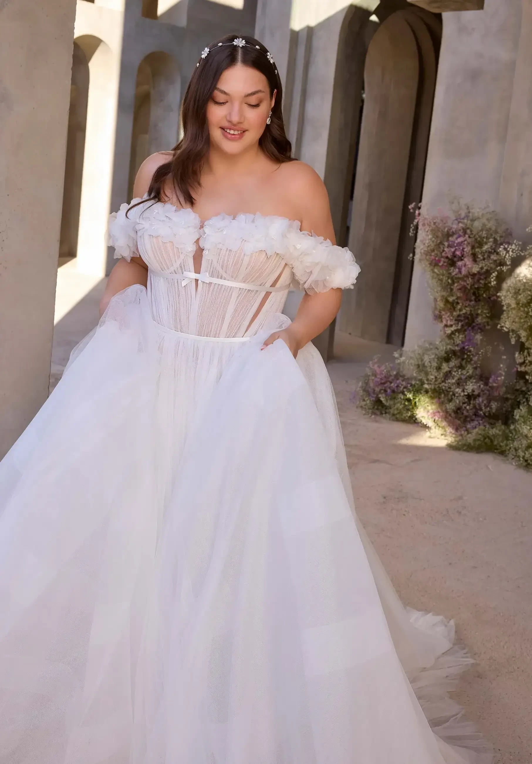 model is wearing an off the shoulder a-line bridal gown