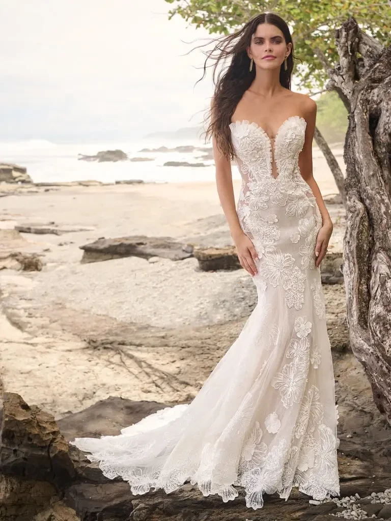 model is wearing a strapless lace fit and flare bridal gown
