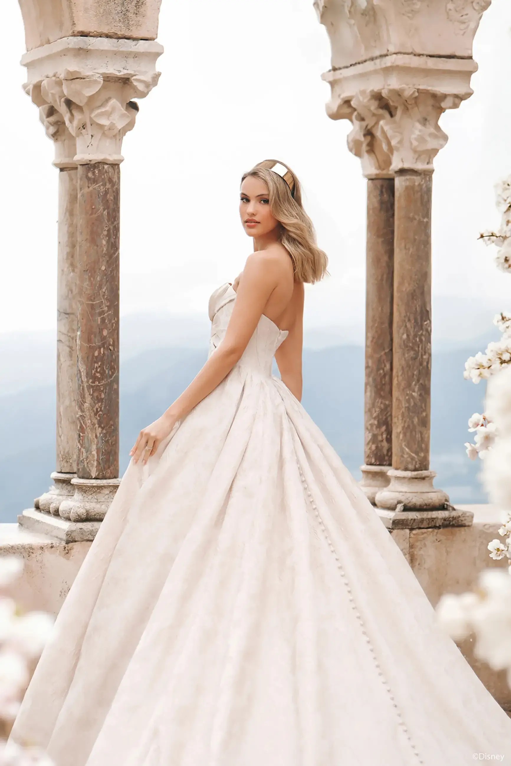 Model is wearing a strapless ball gown wedding dress