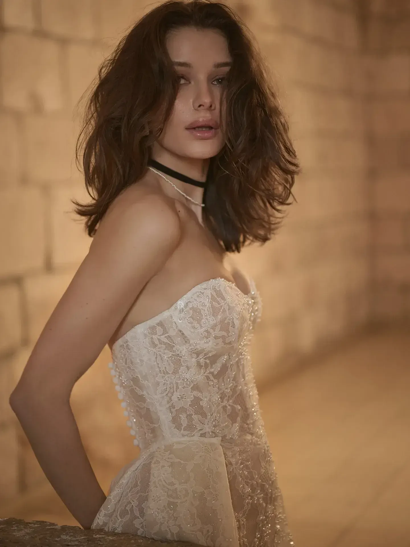 model is wearing a strapless lace fit and flare bridal gown