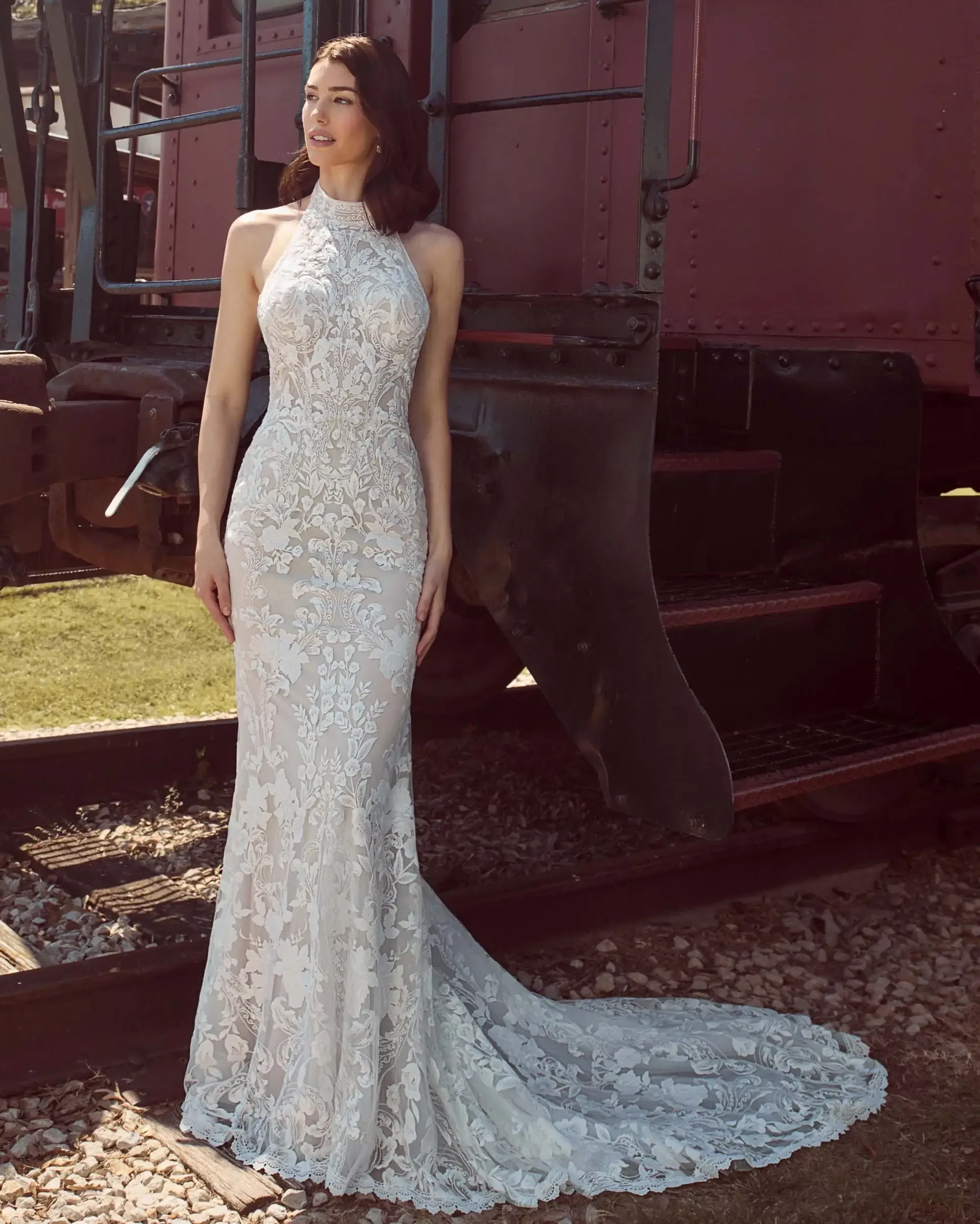 A boho-inspired gown with a halter neckline, floral lace detailing, and an open back framed in delicate lace.